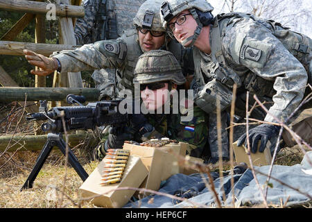 Stati Uniti Paracadutisti dell'esercito, assegnato all'173rd Airborne Brigade truppe speciali Battaglione e un soldato olandese con l'Ingegnere 411 società, xli ingegnere corazzato battaglione, xiii meccanizzata della brigata di fanteria, Royal Netherlands esercito, impegnarsi obiettivi durante una difensiva combinata live-fire esercizio al settimo esercito JMTC Grafenwoehr dell Area Formazione, Germania, 7 marzo 2015. (U.S. Foto dell'esercito PFC. Nathanael Mercado) noi, soldati olandesi di treno sulla difensiva 150317 operazioni-un-AZ999-001 Foto Stock