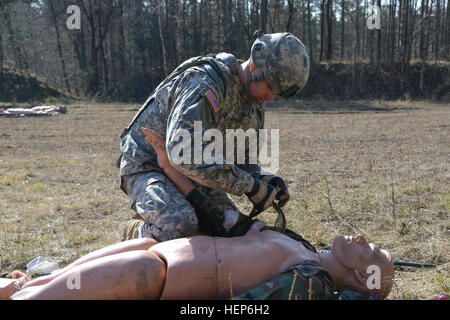 Stati Uniti Il personale dell'esercito Sgt. James Bagsby, assegnato a U.S. Presidio militare di Wiesbaden, fornire assistenza medica a simulare un incidente durante la gestione di installazione comando- Europa guerriero migliore concorrenza a Grafenwoehr, Germania, 10 marzo 2015. (U.S. Esercito foto di Spc. Franklin Moore/ Rilasciato) 2015 Installation Management Command - Europa guerriero migliore concorrenza 150310-A-OO646-183 Foto Stock