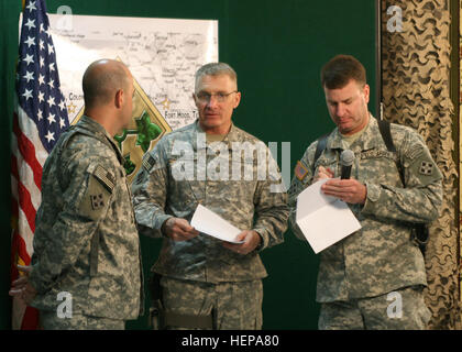 Lt. Col. David Ristedt (sinistra), divisione chirurgo per la quarta divisione di fanteria e divisione multinazionale - a Baghdad e un nativo di Nolanville, Texas, ascolta le istruzioni impartite dalla divisione di comandante generale, il Mag. Gen. Jeffery Hammond (centro), nativo di Hattiesburg, Miss., mentre Lt. Col. Dale Buckner (a destra), comandante della divisione truppe speciali Battaglione e un nativo di Rochester, N.Y., prende appunti in preparazione per la ripartizione mensile del Municipio riunione tenutasi presso l'operazione di Media Center a Camp Liberty, 23 luglio. 4. Inf. Div. slogan ben rappresentati su base mensile town hall mee Foto Stock