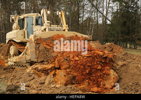 Un U.S. Soldato dell'esercito, del cinquecentesimo Engineer Company, ingegnere xv battaglione, XVIII Polizia Militare brigata, costruisce un serbatoio ostacolo con un bulldozer durante l'esercizio Saber Junction 15 presso l'U.S. Dell'esercito multinazionale comune disponibilità centro in Hohenfels, Germania, 12 aprile 2015. Saber Junction 15 prepara la NATO e partner le forze della Nazione per offensiva e difensiva e operazioni di stabilità e promuove l'interoperabilità tra i partecipanti. Saber Junction 15 ha più di 4.700 partecipanti provenienti da 17 paesi, per includere: Albania, Armenia, Belgio, Bosnia, Bulgaria, Gran Bretagna, Ungheria, Lettonia, Lithua Foto Stock