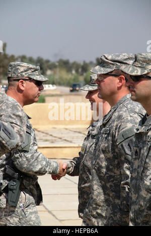 Col. Paolo Calvert, sinistra, comandante della 2a consigliare e assistere brigata, 1a divisione di fanteria, Stati Uniti Division - Centro e un Atene, Ga., nativo, parla con il Mag. Colleen Stephens, behavioral health officer con seconda AAB, 1INF. Div., USD-C, dopo aggiudicazione la sua azione di combattimento il badge a Camp Liberty, Iraq, 27 marzo. Il monogramma prevede il riconoscimento ai non-soldati di fanteria che personalmente impegnare le forze nemiche in combattimento o sono impegnati da un nemico vigore. Insorti utilizzato un anti-armor hand grenade per sferrare un attacco contro un convoglio in cui Stephens era in sella ai primi di marzo. (U.S. Foto dell'esercito da chi Foto Stock