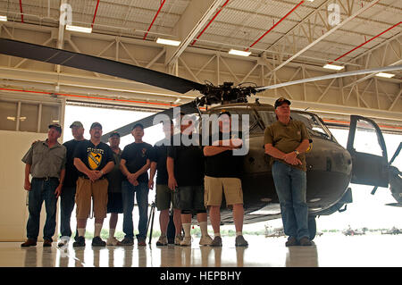 Ex soldati da B Company, 2° Battaglione, quinto reggimento di cavalleria pongono di fronte a un UH-60 Black Hawk elicottero durante la loro riunione annuale visita a Fort Hood, Aprile 23. Più di una dozzina di veterani del Vietnam, i loro coniugi e i familiari hanno dato un tour del 4° Battaglione, 227th aviazione del reggimento hangar e di aeromobili. (U.S. Esercito foto di Sgt. Matthew Thompson, xi Affari pubblici distacco) Ricongiungimento Vietnam veterinari con 1a divisione di cavalleria battaglione 150423-A-OB963-037 Foto Stock