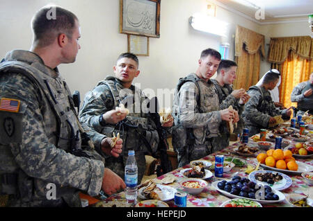 I soldati dalla Divisione multinazionale - Bagdad la società B, 1° Battaglione, 27 Reggimento di Fanteria "Wolfhound," seconda Stryker Brigade Combat Team 'Warrior", XXV divisione di fanteria, godetevi un pranzo in un sceicco home in l' Istiqlal Qada, Agosto 17, 2008, mentre i leader militari e civili discusso i modi per migliorare l'area, a nord-est di Baghdad. Wolfhound gustare pasti a sceicco residence nell' Istiqlal Qada 109794 Foto Stock