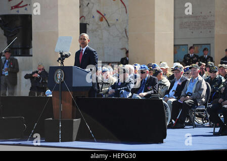 Il presidente Barack Obama parla di oltre 10.000 partecipanti al Normandia Cimitero e memoriale americano a giugno qui 6, che commemora la memoria dei soldati caduti che hanno dato la loro vita 70 anni fa a lottare per liberare l'Europa nordoccidentale. Durante la cerimonia di circa 400 i veterani della Seconda guerra mondiale sedeva dietro i presidenti e di fronte alla folla mentre ascolti i discorsi, quasi tutti reagire con piedi applausi ed emozione come essi sat solo miglia da dove hanno combattuto per la loro vita. La manifestazione è stata una delle diverse commemorazioni del settantesimo anniversario del D-Day operazioni svolte dal al Foto Stock