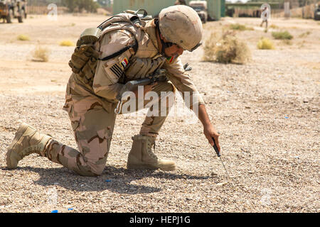 Un soldato iracheno assegnato al ventitreesimo esercito iracheno brigata usa un coltello per individuare un filo di comando durante il contatore esplosivi improvvisati per la formazione del dispositivo a Camp Taji, Iraq, 2 agosto 2015. Formazione presso l'edificio la capacità del partner sites è parte integrante della Combined Joint Task Force - Funzionamento inerenti risolvere la multinazionale di sforzo per treno iracheno forza di sicurezza personale per sconfiggere lo Stato islamico dell Iraq e il levante. Una coalizione di nazioni si sono unite insieme per sconfiggere ISIL e la minaccia che essi rappresentano per l'Iraq, Siria, della regione e della più ampia comunità internazionale. (U.S. Esercito foto di Sgt. C Foto Stock