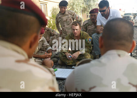 Un soldato australiano assegnati al gruppo di attività insegna Taji soldati iracheni come leggere una mappa durante un sottufficiale classe academy a Camp Taji, Iraq, 11 Agosto, 2015. La combinazione di forze congiunte terra comando di componente - Iraq raccomandato l'accademia come un modo per contribuire a rafforzare la leadership della noncommissioned degli ufficiali di esercito iracheno. Il comando Sgt. Il Mag. Michael Green, comando sergente maggiore di CJFLCC-ho detto che la leadership viene fornito con un obbligo. "Chiunque assumendo una posizione di autorità o di responsabilità ha per soddisfare le richieste competenze di tale posizione," ha detto verde. "L'mo Foto Stock