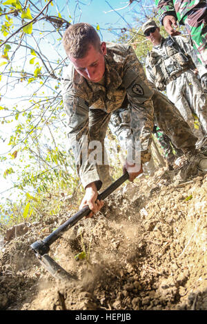 Stati Uniti Army Spc. Michael Kozub, un fante dal Bravo Company, 2-27esimo reggimento di fanteria, 3° della brigata di fanteria, XXV divisione di fanteria, scava una foxhole al fianco di soldati indonesiani 1a Divisione di Fanteria di Kostrad durante la Garuda scudo, Pacific Pathways 2015 in Cibenda, West Java, Indonesia, il 21 agosto 2015. Garuda Shield è un pianificate regolarmente esercizio bilaterale sponsorizzato da U.S. Army-Pacific, ospitato annualmente dal Tentara Nasional Indonesia esercito a promuovere la sicurezza regionale e la cooperazione. (U.S. Esercito Foto di Spc. Michael Sharp/RILASCIATO) Garuda scudo 2015 150821-A-ZD093-086 Foto Stock