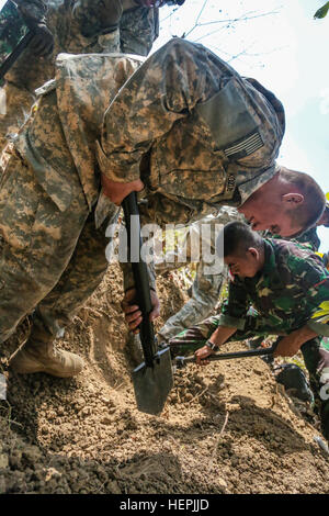 Stati Uniti Army Spc. Michael Kozub, un fante dal Bravo Company 2-27esimo reggimento di fanteria 3° della brigata di fanteria, XXV divisione di fanteria, scava una foxhole al fianco di soldati indonesiani 1a Divisione di Fanteria di Kostrad durante la Garuda scudo, Pacific Pathways 2015 in Cibenda, West Java, Indonesia, Agosto 21, 2015. Garuda Shield è un pianificate regolarmente esercizio bilaterale sponsorizzato da U.S. Army-Pacific, ospitato annualmente dal Tentara Nasional Indonesia esercito a promuovere la sicurezza regionale e la cooperazione. (U.S. Esercito Foto di Spc. Michael Sharp/RILASCIATO) Garuda scudo 2015 150821-A-ZD093-200 Foto Stock