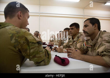 Un soldato australiano Assegnato a gruppo attività Taji parla di un gruppo di soldati iracheni che frequentano il sottufficiale academy presso il Camp Taji, Iraq, 22 Agosto, 2015. Gruppo di attività Taji ha coordinato il concetto dell'Accademia, al fine di insegnare ai sottufficiali iracheno come il treno e la cura per i loro soldati in diverse situazioni. Attraverso lo sviluppo professionale con il governo iracheno sottufficiali, Combined Joint Task Force - Funzionamento inerenti risolvere sta potenziando le forze di sicurezza irachene nella lotta contro lo Stato islamico dell Iraq e il levante. (U.S. Esercito foto di Spc. Parigi Maxy/RILASCIATO) iracheni frequentano NCO academy 15082 Foto Stock