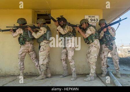 Soldati iracheni assegnati 71st esercito iracheno pratica della brigata mobile attraverso una città pur partecipando in un assalto scenario durante le operazioni in ambiente urbano della formazione di Camp Taji, Iraq, nov. 3, 2015. I soldati hanno imparato a garantire gli edifici in preparazione per la loro lotta contro lo Stato islamico dell Iraq e il levante (ISIL). Formazione presso l'edificio la capacità del partner sites è parte integrante della Combined Joint Task Force - Funzionamento inerenti risolvere multinazionale dell impegno di addestrare le forze di sicurezza irachene personale per sconfiggere ISIL. Una coalizione di enti regionali e internazionali hanno delle nazioni unite insieme t Foto Stock