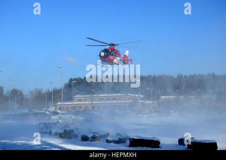 Un Eurocopter EC 135 con il tedesco Air Rescue Service terre nella parte anteriore del guerriero unità di transizione la costruzione dell'edificio rosa sulla caserma per una missione di emergenza, Vilseck, Germania, gennaio 19, 2016. (U.S. Esercito foto di Visual Information Specialist Matthias Fruth/RILASCIATO) Air Rescue Service 160119-A-FS311-001 Foto Stock