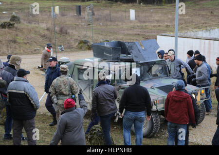 Soldati rumeni del 265Polizia Militare Battaglione tentare di lasciare una città in un Humvee durante la conduzione di un prigioniero simulato di estrazione durante l'esercizio di una forza per il Kosovo (KFOR) Missione prove generali di esercizio (MRE) al giunto multinazionale Centro Readiness in Hohenfels, Germania, Feb 24, 2016. La KFOR MRE 21 è basato sull'attuale ambiente operativo ed è progettato per preparare l'unità per il sostegno della pace e della stabilità e le operazioni di emergenza in Kosovo a sostegno delle autorità civili per mantenere un ambiente sicuro e protetto. (U.S. Foto dell'esercito da Staff Sgt. Nathaniel Allen/RILASCIATO) KFOR Foto Stock