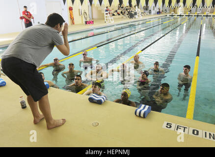 Esercito degli Stati Uniti servizio attivo e il veterano gli atleti si riuniscono intorno come nuotare coach Bobby Brewer dà istruzioni al Aquatics Training Center, Fort Bliss, Texas, 28 febbraio, 2016. Più di 100 feriti e ammalati e feriti i soldati e i veterani sono a Fort Bliss per treno e competere in una serie di eventi sportivi tra cui tiro con l'arco, ciclismo, tiro, seduta pallavolo, nuoto, via, il campo e basket in carrozzella. Sentieri dell'esercito, marzo 6-10, sono condotti dal Dipartimento della Difesa Warrior giochi esercito 2016 Team, circa 250 atleti, in rappresentanza di squadre dell'esercito, Marine Corps, Marina, Aria per Foto Stock