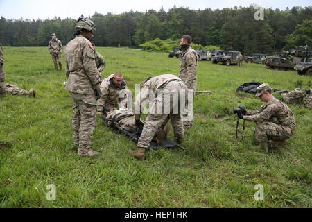 Stati Uniti Soldati di alfa e Bravo Company, 5° Battaglione, 7° reggimento di cavalleria fornire aiuto medico per simulare un incidente mentre U.S. Army Sgt. Matteo Hulett di Viper della squadra, multinazionale comune Readiness Center (JMRC) (gruppo Operations) i documenti di formazione durante la fase di esercizio combinato di risolvere VI presso l'U.S. Dell'esercito in JMRC Hohenfels, Germania, 19 maggio 2016. Esercizio combinato di risolvere vi è progettato per esercitare la U.S. Dell'esercito a livello regionale assegnato forza per gli Stati Uniti Comando europeo area di responsabilità con la multinazionale la formazione a tutte le gerarchie. Circa 570 partecipanti provenienti da 5 NATO e Unione Foto Stock