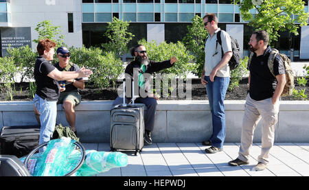 Stati Uniti il Comando Operazioni Speciali atleti salutarci come essi arrivano per il 2016 per il Dipartimento della Difesa Warrior giochi presso l'Accademia Militare degli Stati Uniti a West Point, New York, 10 giugno 2016. Il DOD Warrior giochi è adattativa di competizione sportiva per i feriti e ammalati e feriti servicemembers e i veterani. Gli atleti in rappresentanza di squadre dell'esercito, Marine Corps, Marina, Air Force, Stati Uniti il Comando Operazioni Speciali e le forze armate del Regno Unito si sfideranno in pista, campo di tiro con l'arco, ciclismo, tiro, nuoto, seduta a pallavolo e basket in carrozzella a partire 15 Foto Stock