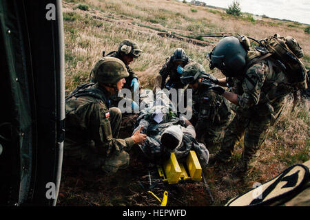 Sgt. Jamie Fox (a destra), un combattimento Medic assegnato alla società C., 2° Battaglione, 227th reggimento di aviazione, 1° aria brigata di cavalleria guide soldati polacchi verso dopo la risposta a un nove-line medevac durante l'esercizio Anakonda 2016 (un16) a Miroslawiec Air Base, Polonia, 11 giugno 2016. Un16 un polacco-led, multinazionale di evento di formazione in funzione da giugno 7-17, coinvolge circa 31.000 partecipanti provenienti da più di 20 nazioni ed è il principale evento di formazione per gli Stati Uniti Esercito europeo. Live Mascal Formazione a esercitare Anakonda 2016 160611-A-YT518-003 Foto Stock