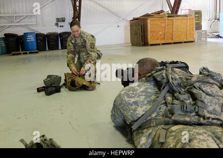 Stati Uniti Army Spc. Kristen Root prepara il cablaggio che ella si usurano mentre sul bordo della CH47-Chinook mentre U.S. Army Sgt. Bobby Allen spara le foto. Entrambi i soldati sono dal 982nd combattere la fotocamera e società sono state documentando il Singapore Air Force nel Ellsworth Air Base, S.D., 14 giugno 2016. (U.S. Esercito Foto di Sgt. Alfonso Corral) Soldato prepara il cablaggio prima di salire a bordo di CH47 Chinook 160614-A-JP694-117 Foto Stock