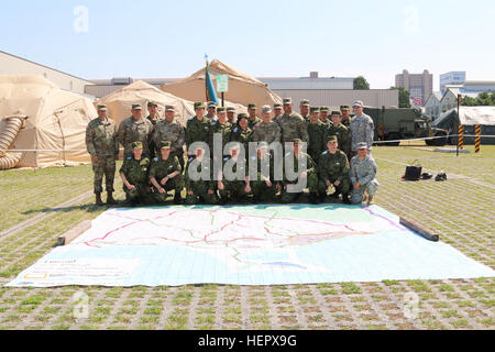 Stati Uniti e Giappone terra Forza di Autodifesa (JGSDF) servizio membri posano per una foto dietro un 30 da 30 piedi al di fuori della mappa Sagamihara Depot missione complesso di formazione durante una visita da Briga. Gen. Stephen K. curda, Commander, 9 Supporto di missione di comando e di esercizio Imua Alba 2016, Sagamihara, Giappone, 18 giugno 2016. Imua Alba 2016 fornisce opportunità per gli Stati Uniti e le forze giapponesi a venire insieme e treno per il reale potenziale degli eventi mondiali, meglio la loro preparazione nel sostenere le popolazioni regionali in tutta l'assistenza umanitaria e di soccorso in caso di catastrofe (HADR) e Noncombatant operazioni di evacuazione (NEO). Foto Stock