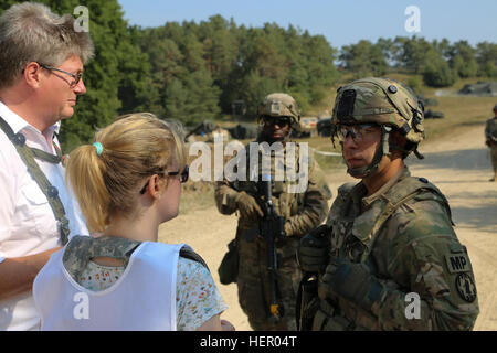 Un U.S. Soldato, a destra dell'ottantanovesimo Polizia Militare Brigata parla con i civili role-playing personale medico mentre si conduce una forza sulla forza lo scenario di addestramento durante l esercizio fisico combinato risolvere VII presso l'U.S. Dell'esercito multinazionale comune disponibilità Centro Hohenfels in Germania, Sett. 11, 2016. Combinate risolvere VII è un settimo Esercito di formazione comando, U.S. Esercito Europa-diretto esercizio, che si svolge presso il Grafenwoehr Hohenfels e le aree di formazione, 8 agosto a settembre 15, 2016. Questo esercizio è progettato per addestrare l'esercito è assegnato a livello regionale le forze per gli Stati Uniti Comando europeo. Combinate risolvere VII include Foto Stock
