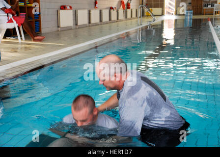 Cappellano Lt. Col. Joel Severson, Task Force 34 Cappellano, sommerge Spc. Benjamin Peterson, HSC 834th cappellano ASB era assistente, sotto l'acqua. Sei Task Force 34 soldati di acqua sono stati battezzati nella Turner piscina coperta a base comune Balad, Iraq il 26 ottobre. I soldati ricevano il battesimo dell'acqua in terra biblica 128397 Foto Stock