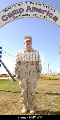 GUANTANAMO Bay a Cuba - Coast Guard Petty Officer 1. Classe Russell Wolfe, un specialista di operazioni con la Guardia Costiera della riserva porta unità di sicurezza 307, in posa per una foto sotto la Joint Task Force Guantanamo's Camp America segno, nov. 13, 2008. Wolfe è andato prima di un consiglio di amministrazione di sei senior personale arruolato e ha vinto la meta ambita di Senior JTF Trooper dell'anno. JTF Guantanamo conduce al sicuro, umano, legale e trasparente di cura e custodia dei detenuti combattenti ostili, compresi quelli condannati dalla commissione militare e quelli ordinati rilasciato. La JTF conduce la raccolta di intelligence, analys Foto Stock