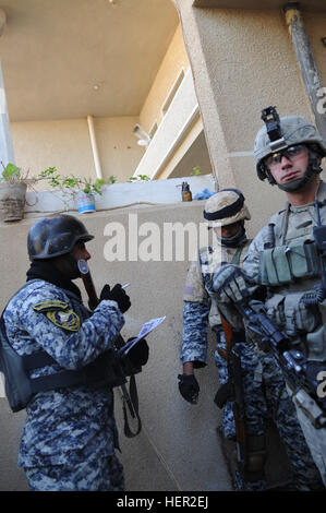 Sgt. Jeremy birra si interroga su quale tipo di telecamera viene utilizzato per prendere la sua immagine mentre U.S. Soldati del primo battaglione, 27 Fanteria, XXV divisione di fanteria lungo con soldati dell'esercito iracheno condurre un quartiere pattuglia di presenza in un Basateen Hayy di Baghdad, Iraq, 7 dicembre, 2008. Giunto negli Stati Uniti e in presenza irachena pattuglia 136361 Foto Stock