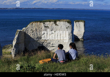 Una giovane coppia che si affaccia su un vecchio Harry rocce, vicino a Swanage, Dorset, Inghilterra, Regno Unito. Foto Stock