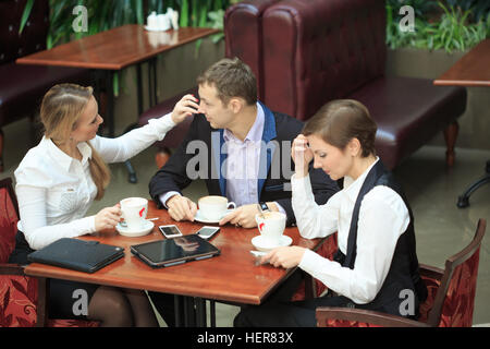 Uomini d'affari in seduta cafe per un laptop. Due ragazze Foto Stock