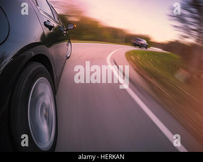 Guida auto a velocità su strada curva Foto Stock