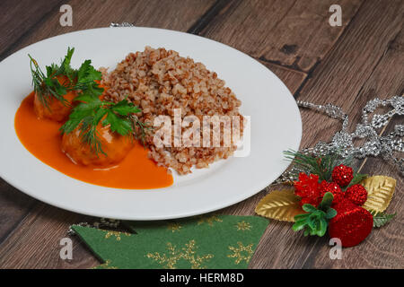 Farinata di grano saraceno e polpette di carne sul tavolo di legno vicino a albero di Natale giocattoli Foto Stock