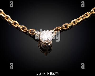 Collana dorata con pietra isolato su sfondo nero. Foto Stock