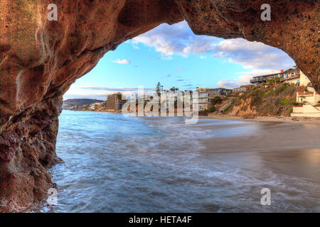 Tramonto hits case lungo Pearl Street Beach attraverso una roccia toppa in Laguna Beach, California, Stati Uniti d'America Foto Stock