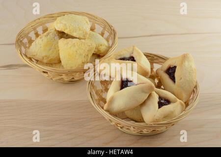 Hamantash e scones in cesti di vimini sul tavolo di legno Foto Stock