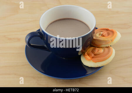 Tazza di cioccolata calda con due zucca frosted cookie sul piattino Foto Stock