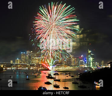 Sydney Nuovo Anno fuochi d'artificio su city CBD e acque del porto con la folla di specators e yacht. Multi-colore sfere di luce nel cielo illuminano Australi Foto Stock