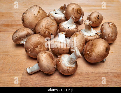 Gran Royal di funghi champignon con varietà marrone su un tagliere di legno. Foto Stock