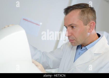Felice giovane maschio ricercatore lavorando nel suo laboratorio Foto Stock