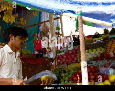 Goa, India - 16 dicembre 2016: una strada fornitore di frutta si prepara una noce di cocco verde per il consumo Foto Stock