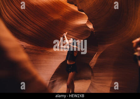 Donna prendendo fotografia in grotta, Antelope Canyon, Pagina, Arizona, Stati Uniti d'America Foto Stock