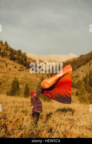 Donna incinta in piedi in campo, scuotendo il sacco a pelo, minerale re, Sequoia National Park, California, Stati Uniti d'America Foto Stock