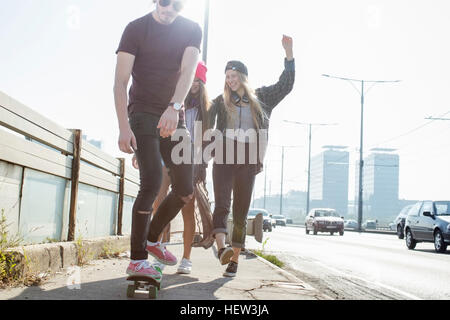 Skateboarders camminare e skateboard insieme su street, Budapest, Ungheria Foto Stock