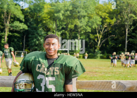 Ritratto maschile teenage giocatore di football americano casco di contenimento al campo da gioco Foto Stock