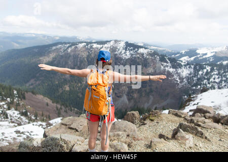 Giovane donna in piedi sulla roccia, guardando a vista, vista posteriore, Silver Star Mountain, Washington, Stati Uniti d'America Foto Stock