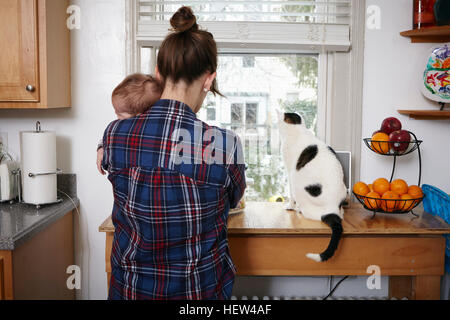 Vista posteriore della madre holding sleeping baby boy Foto Stock