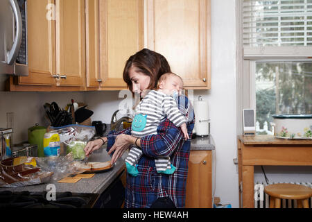 Azienda madre sleeping baby boy e la preparazione di sandwich Foto Stock