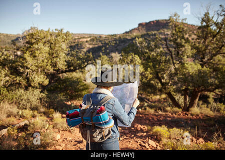 Donna in ambiente rurale, guardando la mappa, vista posteriore, Sedona, in Arizona, Stati Uniti d'America Foto Stock