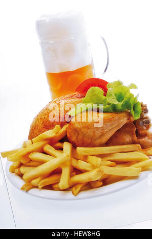 Un intero pollo alla griglia su una piastra bianca con patatine fritte e tazza piena di birra Foto Stock