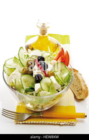 Insalata greca con formaggio feta, il Gherkin, il pomodoro, le foglie di lattuga, peperoncino, e verde e olive nere presentato con una forcella, Foto Stock