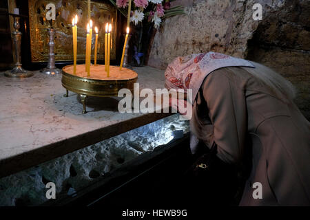 Una chiesa russo-ortodossa adoratore pregando sulla tomba di Maria all interno della chiesa dell Assunzione noto anche come chiesa del sepolcro di Santa Maria o la tomba di Maria Vergine, situato lungo il torrente Kidron prima di Getsemani ai piedi del Monte degli Ulivi, Gerusalemme est Israele Foto Stock
