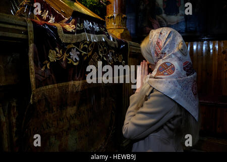 Una chiesa russo-ortodossa adoratore di pregare all interno della chiesa dell Assunzione noto anche come chiesa del sepolcro di Santa Maria o la tomba di Maria Vergine, situato lungo il torrente Kidron prima di Getsemani ai piedi del Monte degli Ulivi, Gerusalemme est Israele Foto Stock